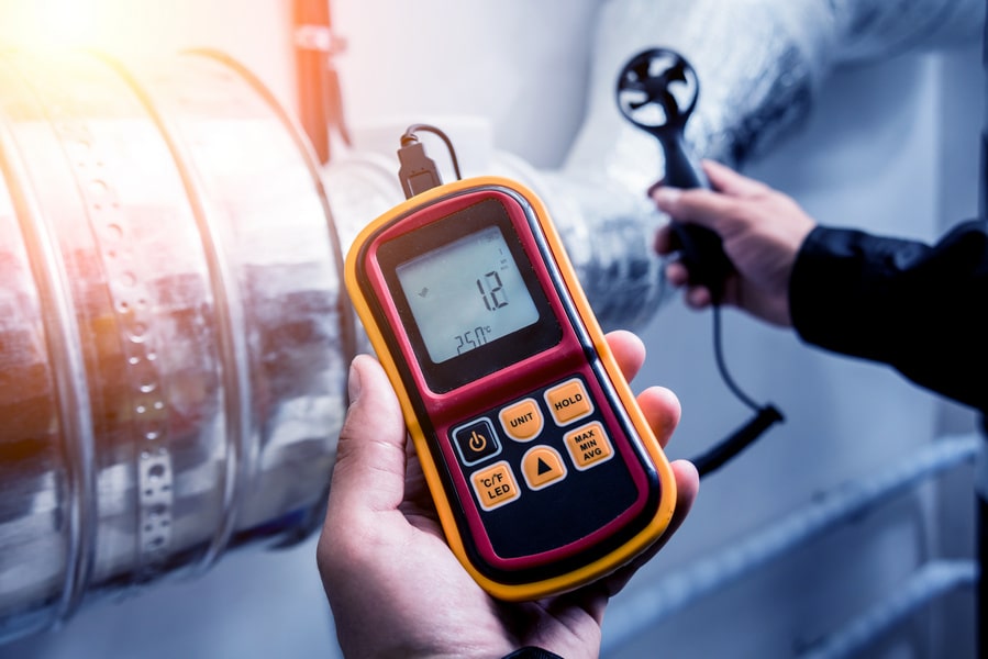 Airflow testing with a rotating vane anemometer as part of our commissioning process